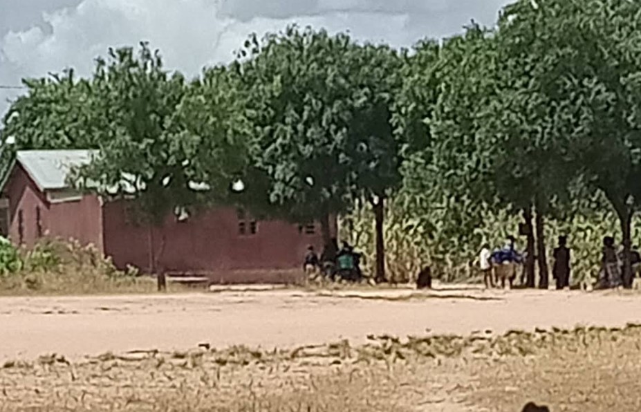 Einfaches Schulgebäude in Nala Tansania mit Kindern im Außenbereich unter Bäumen