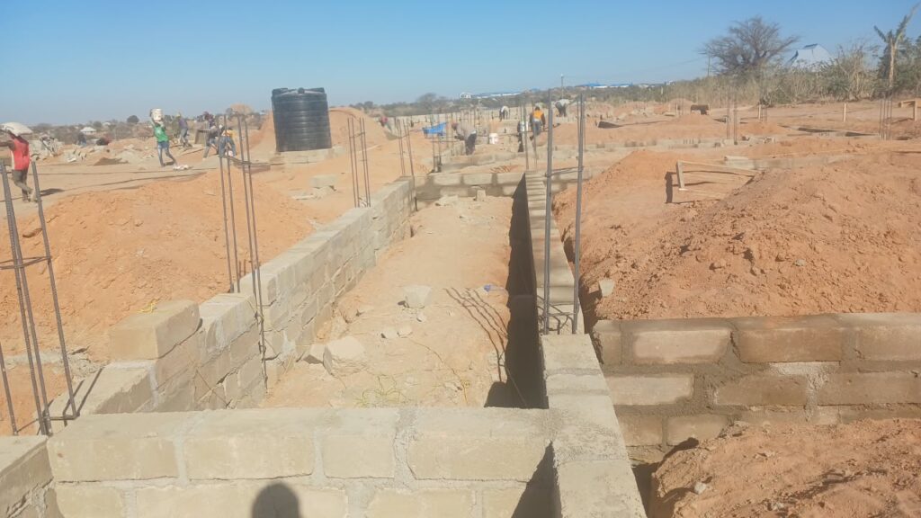 Fundamente der Secondary School in Nala, Tansania. Auf der Baustelle sind erste Mauern, Arbeiter und Infrastruktur für den Bau eines neuen Schulgebäudes sichtbar.