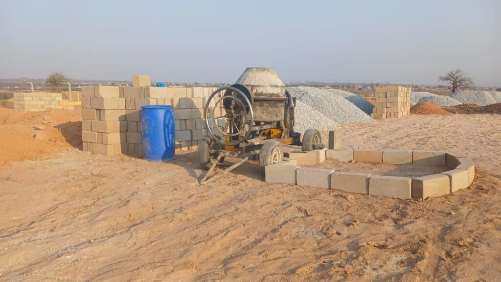 Baumaterialien und Betonmischer auf der Baustelle der Secondary School in Nala, Tansania.